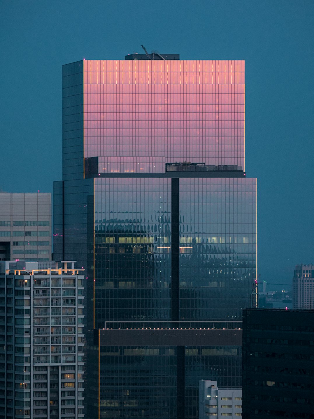 Modern skyscrapers rise against a dark city sky.