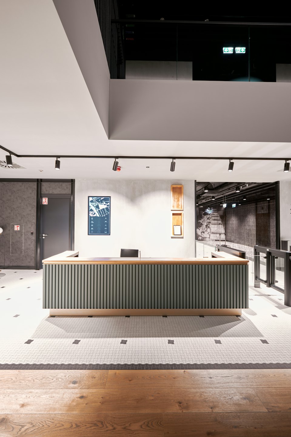 Reception desk with wood and green slats in a modern office.
