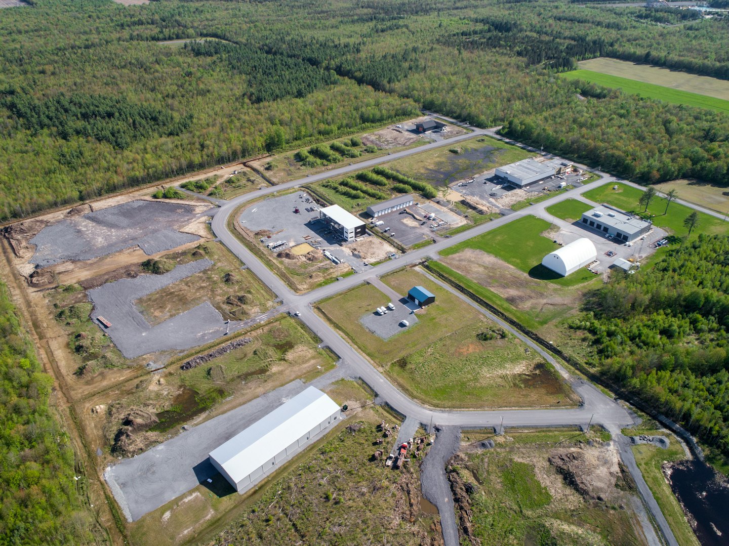 Aerial view of an industrial park under construction surrounded by forest.