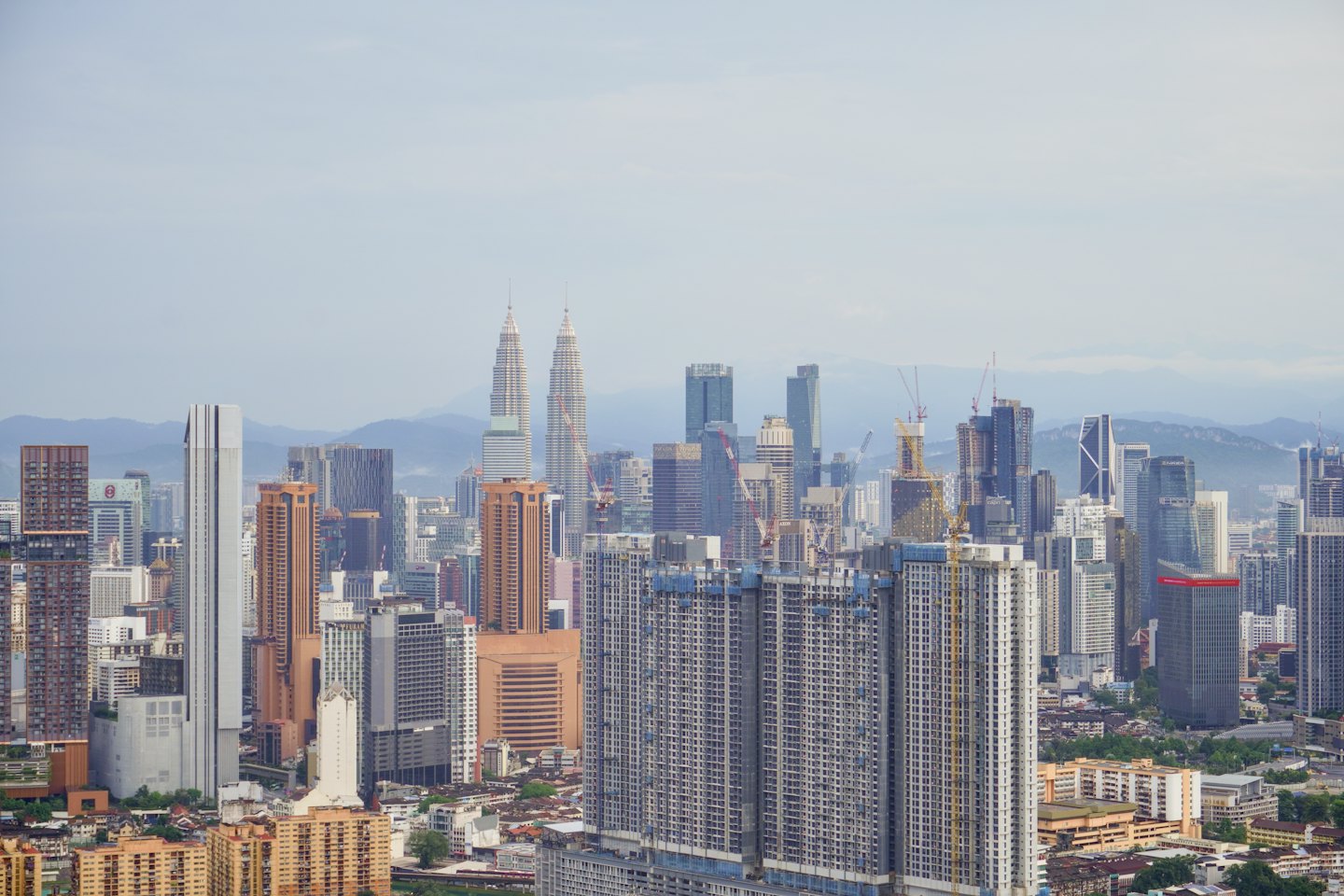 Modern skyscrapers and construction cranes tower over the city landscape.